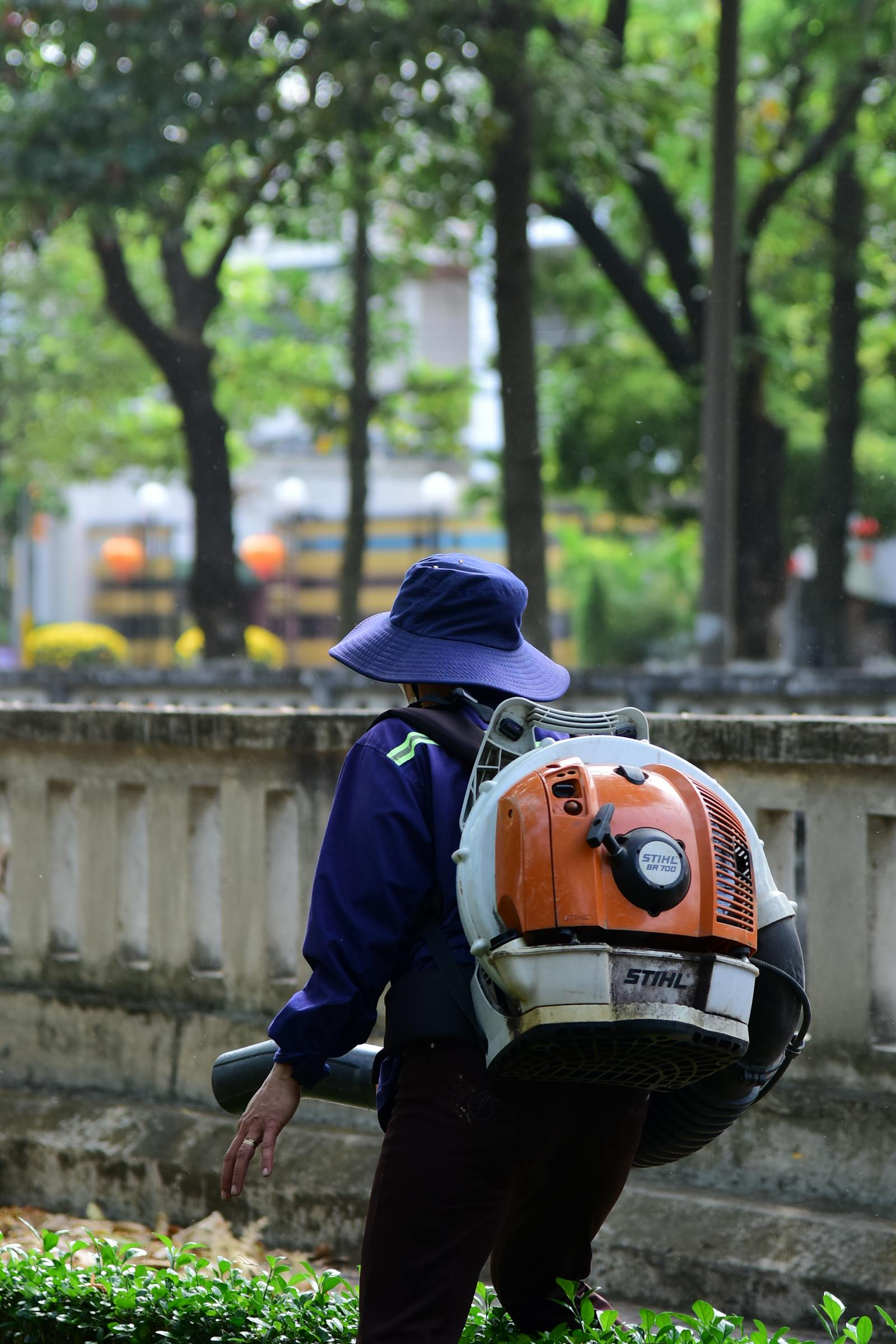 Backpack-blower clearing fall leaves into a tidy pile on a Kingwood lawn.